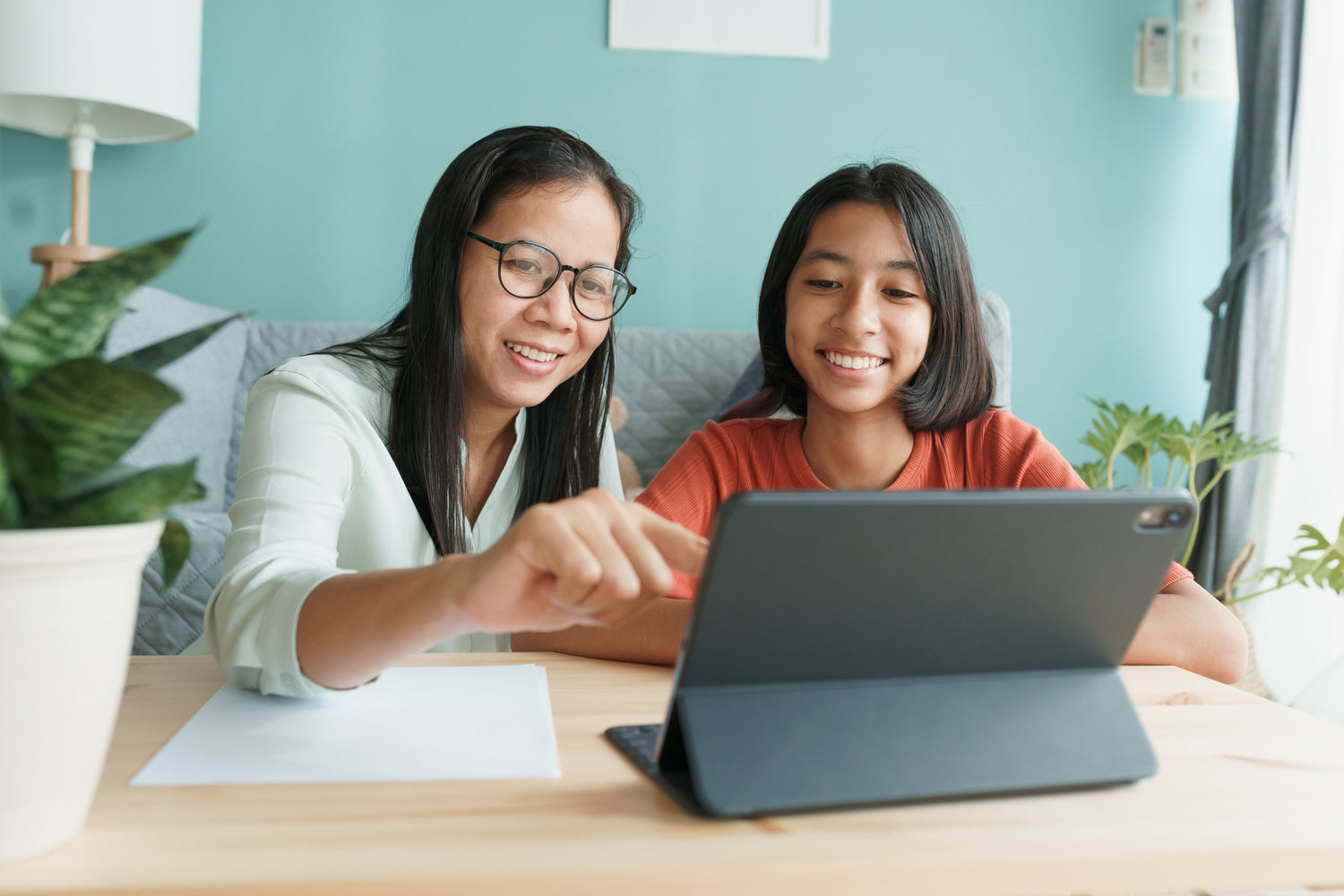 Parent with Child sitting and looking at a tablet together